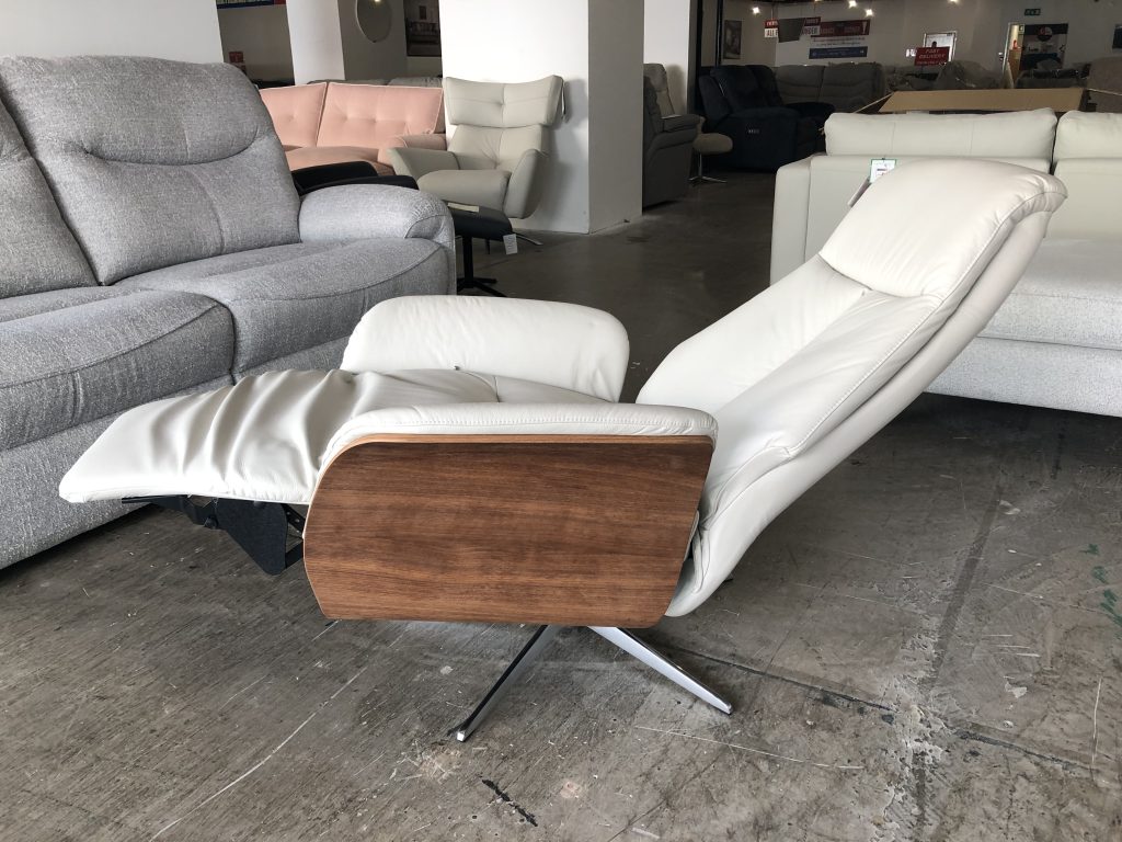 Modern pad-over-chaise cushion detail gives additional comfort & support when in recline. Choose from a black or chrome base. Full veneered side available in Light or Dark Wood. Halburg is a Manual Chair with a Manual Adjustable Footrest & Headrest for added support and comfort.